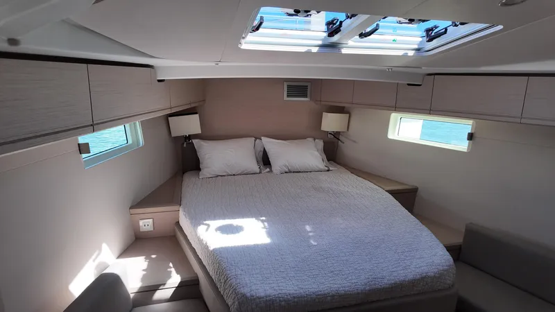  Yacht Photos Pics Luxurious cabin interior of 2021 Jeanneau 51 yacht with skylight and cozy bed.