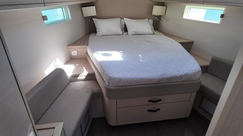  Yacht Photos Pics Luxurious bedroom interior of 2021 Jeanneau 51 yacht with double bed and seating area.