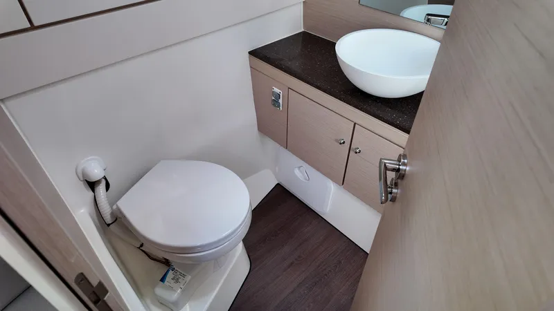  Yacht Photos Pics Modern bathroom in 2021 Jeanneau 51 yacht with toilet and vessel sink.