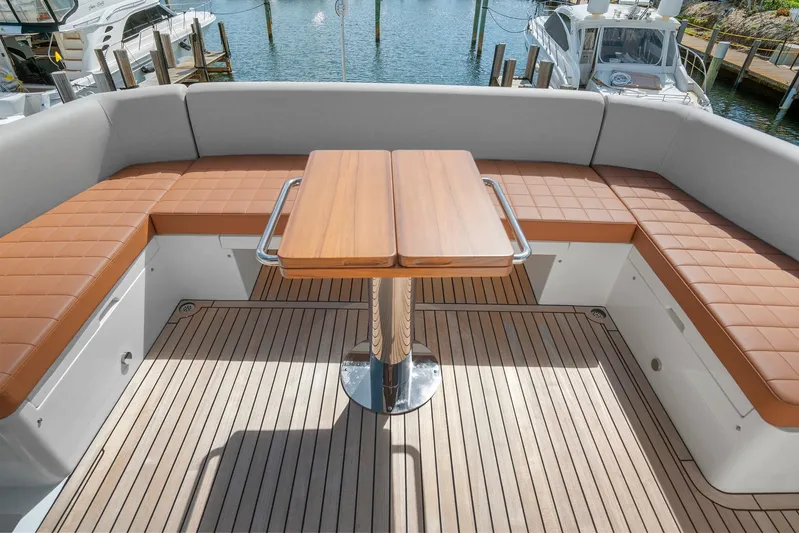 My Way Yacht Photos Pics 2023 Astondoa AS5 yacht deck with cushioned seating and wooden table.