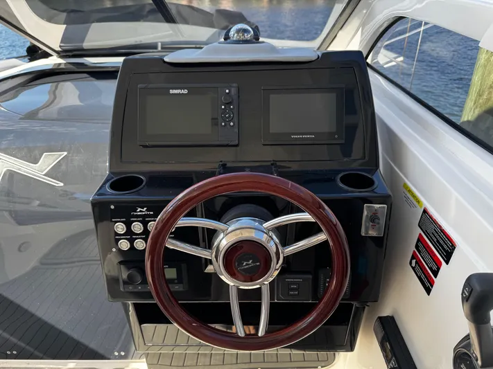  Yacht Photos Pics 2024 NX Boats 280 Xtreme dashboard with steering wheel and navigation controls.