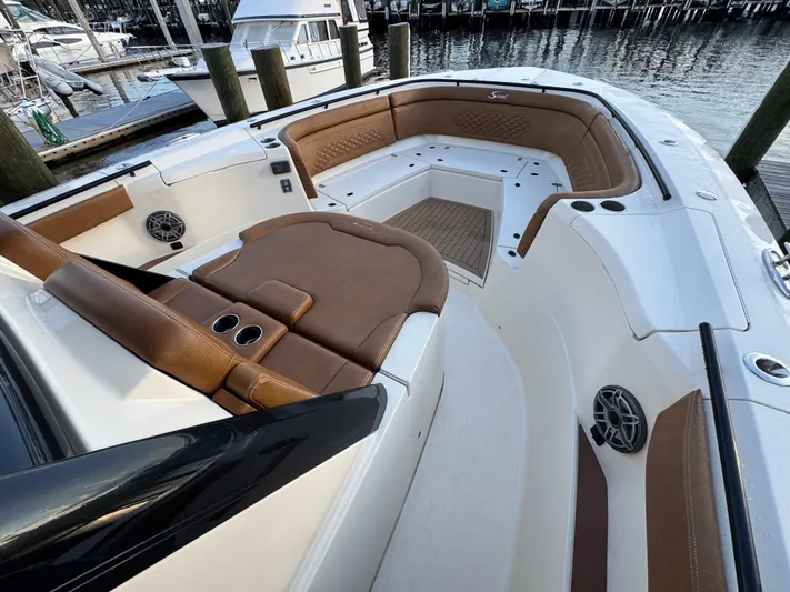  Yacht Photos Pics 2021 Scout 330 LXF boat interior with brown leather seating and cup holders.