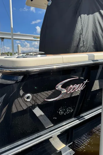  Yacht Photos Pics 2021 Scout 330 LXF boat with sleek black exterior and logo, docked under a sunny sky.
