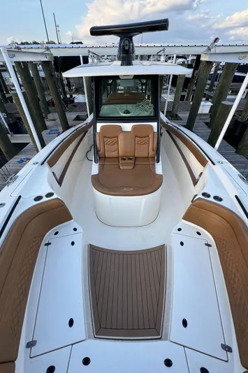  Yacht Photos Pics 2021 Scout 330 LXF boat with brown seating and white deck at a marina.