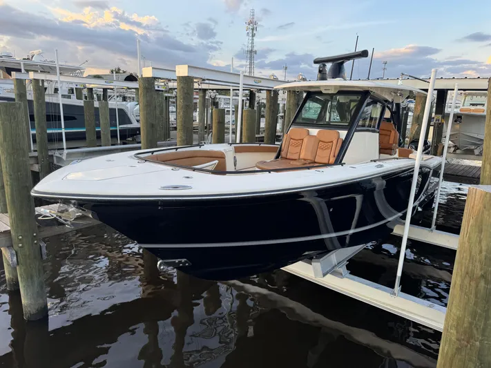 Yacht Photos Pics 2021 Scout 330 LXF boat docked, featuring sleek design and luxurious seating.