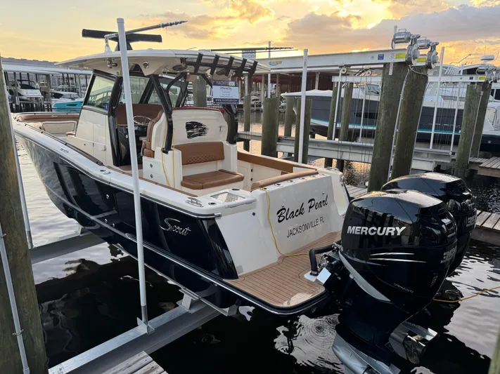  Yacht Photos Pics 2021 Scout 330 LXF boat docked with twin Mercury engines at sunset.