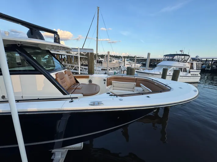  Yacht Photos Pics 2021 Scout 330 LXF boat docked at marina, featuring sleek design and luxurious seating.