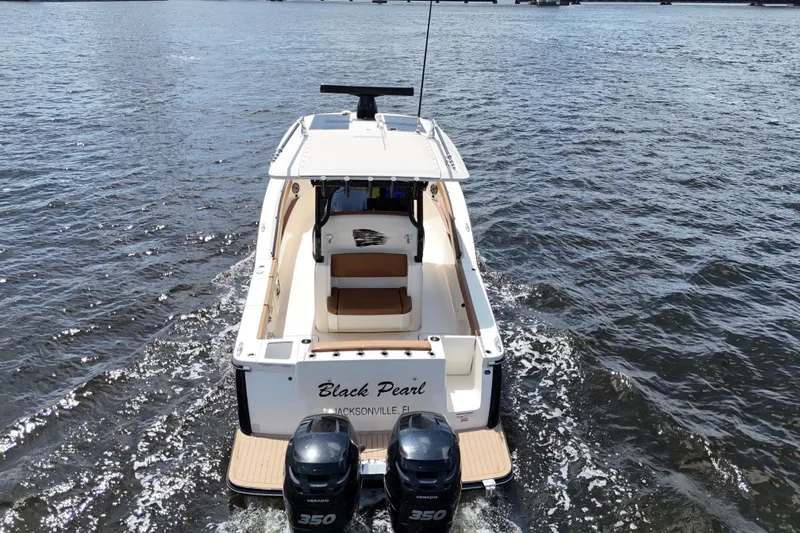  Yacht Photos Pics 2021 Scout 330 LXF boat cruising on water, rear view with twin engines.