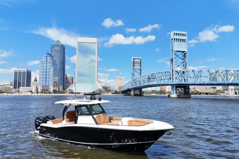  Yacht Photos Pics 2021 Scout 330 LXF boat on river with city skyline and blue bridge.