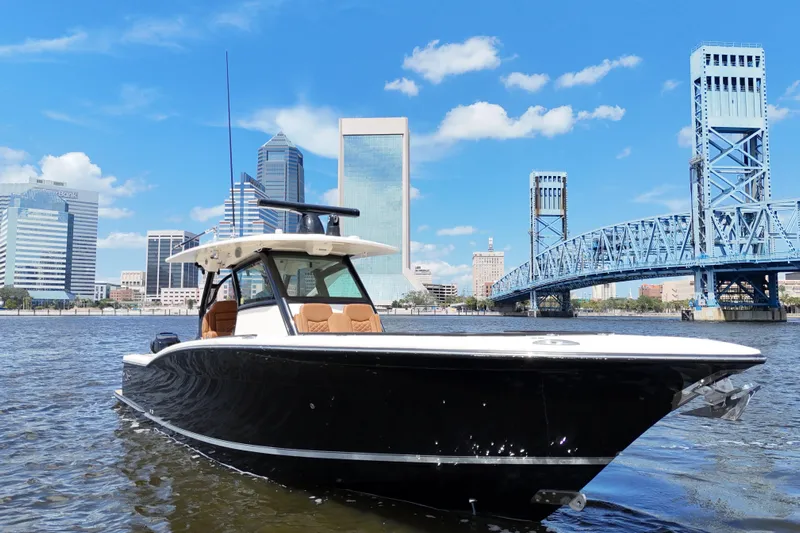  Yacht Photos Pics 2021 Scout 330 LXF boat on water with city skyline and bridge background.