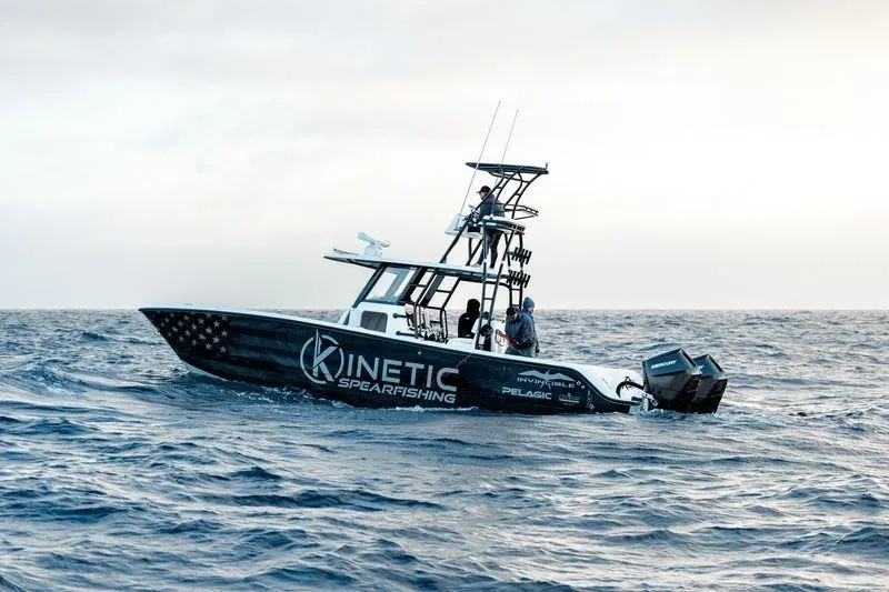 Reaper Yacht Photos Pics 2024 Invincible 33 Catamaran on ocean, featuring "Kinetic Spearfishing" branding.