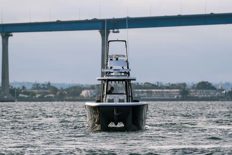 Reaper Yacht Photos Pics 2024 Invincible 33 Catamaran cruising under a bridge on a calm waterway.