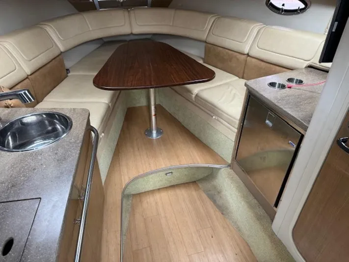  Yacht Photos Pics 2013 Formula 350 Sun Sport cabin with beige seating, wooden table, and kitchenette.