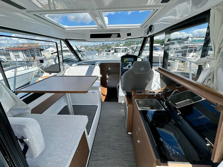 Pearl Yacht Photos Pics Interior of 2024 Jeanneau NC 895 boat, featuring modern seating and kitchen area.