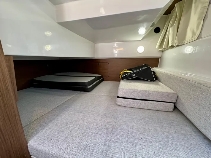 Pearl Yacht Photos Pics 2024 Jeanneau NC 895 cabin interior with cushions and storage space.