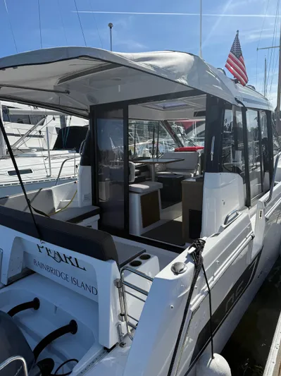 Pearl Yacht Photos Pics 2024 Jeanneau NC 895 boat docked, featuring a spacious interior and American flag.