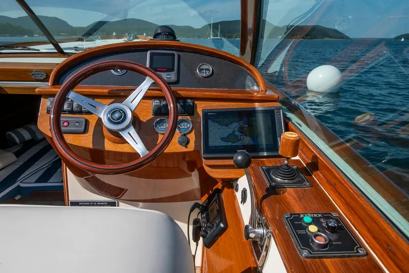 Pappy Yacht Photos Pics 2004 Hinckley Talaria 29 Runabout dashboard with wooden steering wheel and navigation controls.