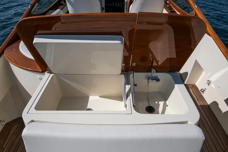 Pappy Yacht Photos Pics 2004 Hinckley Talaria 29 Runabout interior with open storage and sink, featuring wooden accents.