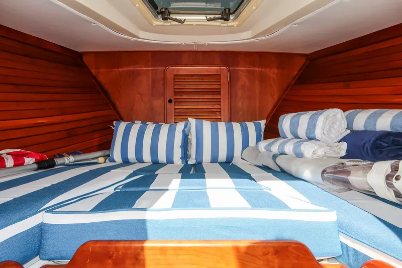 Pappy Yacht Photos Pics Cozy cabin interior of 2004 Hinckley Talaria 29 Runabout with striped bedding.