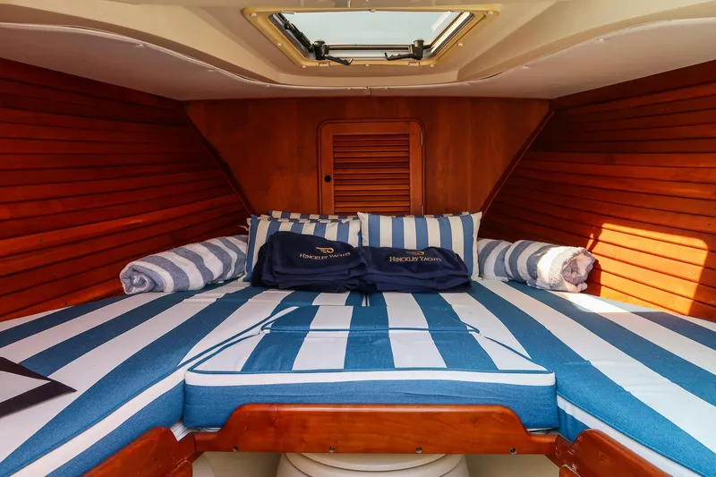 Pappy Yacht Photos Pics 2004 Hinckley Talaria 29 Runabout cabin with striped bedding and wooden interior.
