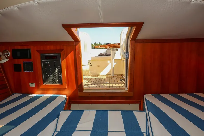Pappy Yacht Photos Pics Interior of 2004 Hinckley Talaria 29 Runabout with striped seating and wooden paneling.