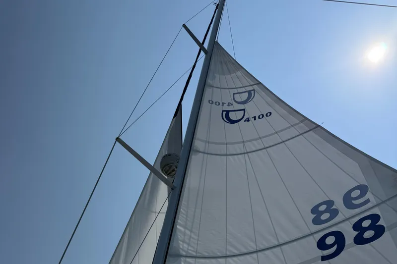 Nino Yacht Photos Pics Sailboat Tartan 4100 from 2007 with sails against a clear blue sky.