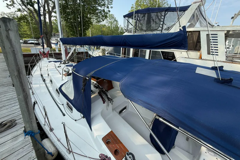 Nino Yacht Photos Pics 2007 Tartan 4100 sailboat docked, featuring blue canvas covers and sleek white deck.