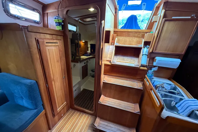 Nino Yacht Photos Pics Interior of 2007 Tartan 4100 sailboat with wooden cabinetry and compact kitchen area.