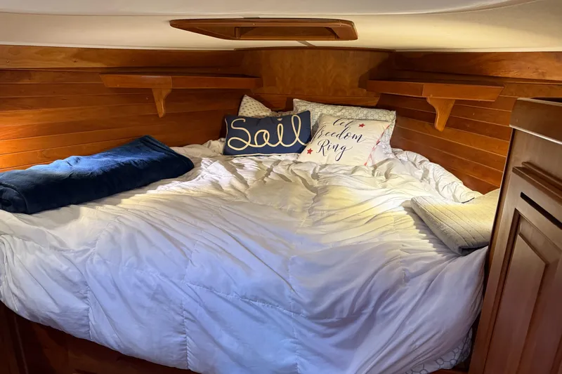 Nino Yacht Photos Pics Cozy cabin bed in 2007 Tartan 4100 sailboat with nautical-themed pillows.