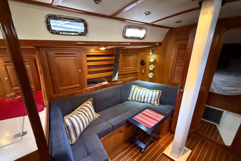 Nino Yacht Photos Pics Cozy interior of 2007 Tartan 4100 sailboat with wooden finish and blue seating.