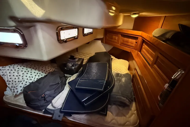 Nino Yacht Photos Pics Cozy cabin interior of 2007 Tartan 4100 sailboat with cushions and wooden storage.