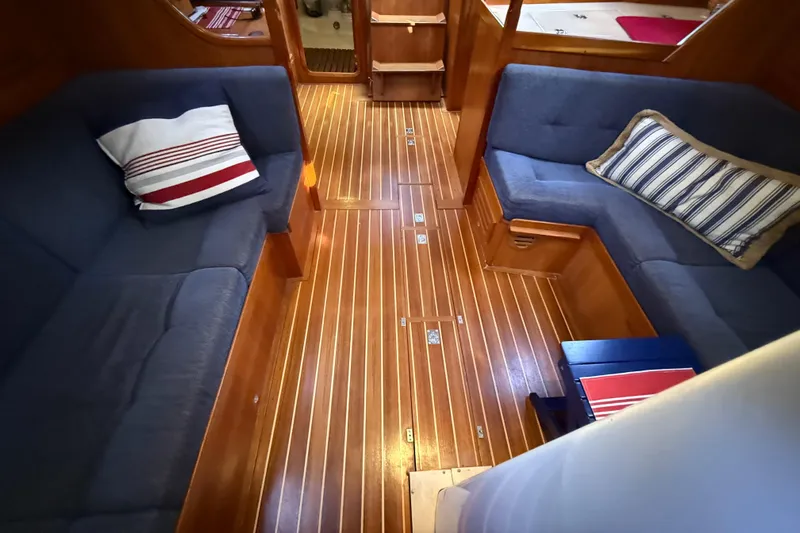 Nino Yacht Photos Pics Interior of 2007 Tartan 4100 sailboat with wooden flooring and blue cushioned seating.
