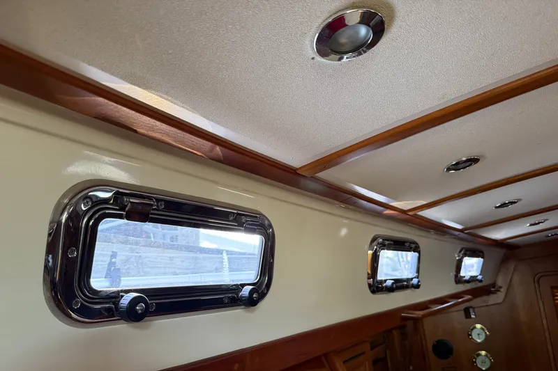 Nino Yacht Photos Pics Interior of 2007 Tartan 4100 yacht with portholes and wooden trim.