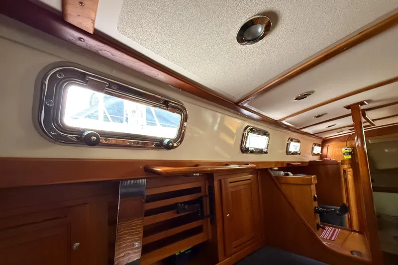 Nino Yacht Photos Pics Interior of 2007 Tartan 4100 sailboat with wooden cabinetry and portholes.