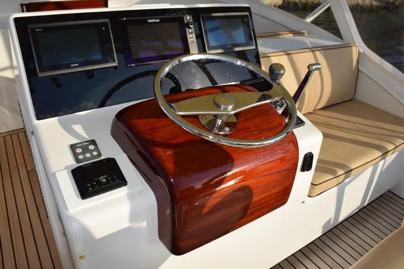 Osprey Yacht Photos Pics Custom helm wheel with speed knob, newer Garmin displays with a Simrad MFD in center (displays engine gauges).