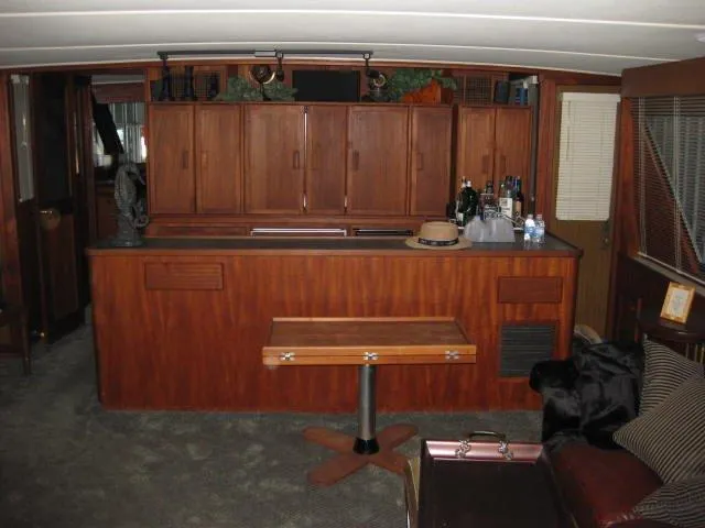  Yacht Photos Pics 1984 Chris-Craft Constellation interior with wooden cabinetry and bar area.