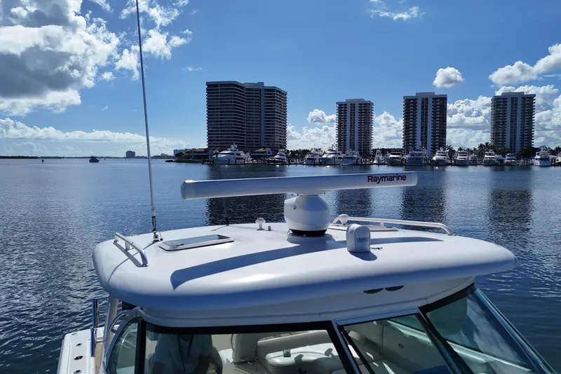  Yacht Photos Pics 2010 Pursuit OS 345 Offshore boat on calm water with city skyline in background.