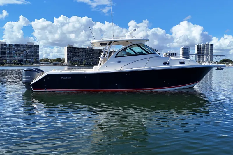  Yacht Photos Pics 2010 Pursuit OS 345 Offshore boat on calm water with city skyline background.
