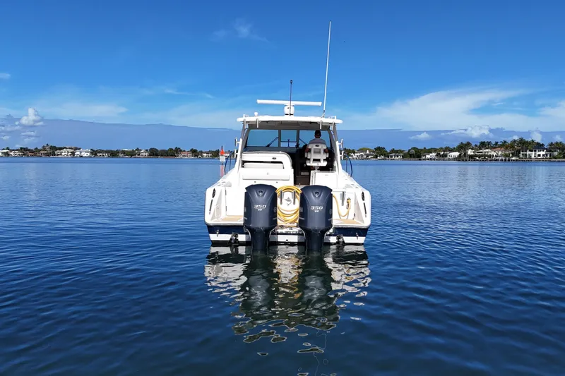  Yacht Photos Pics 2010 Pursuit OS 345 Offshore boat on calm water, clear blue sky background.