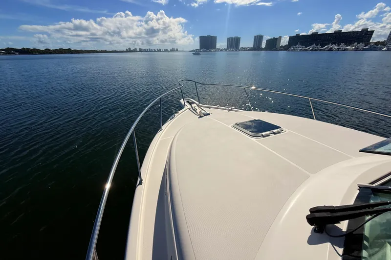  Yacht Photos Pics 2010 Pursuit OS 345 Offshore boat on calm water with city skyline in background.