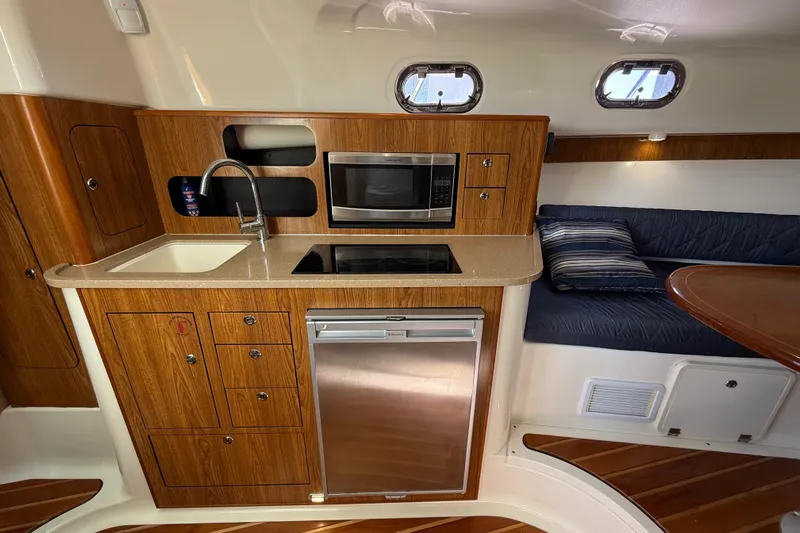  Yacht Photos Pics 2010 Pursuit OS 345 Offshore yacht interior with kitchenette and seating area.