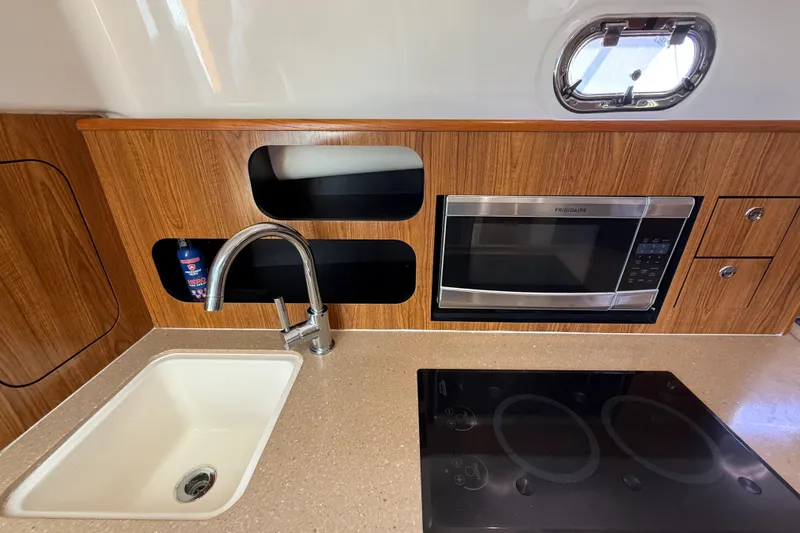  Yacht Photos Pics 2010 Pursuit OS 345 Offshore kitchen with sink, microwave, and stovetop.