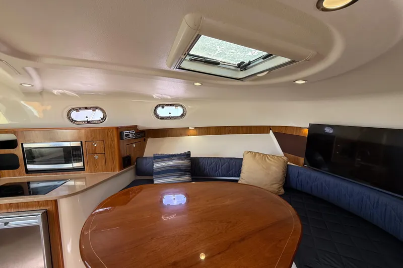  Yacht Photos Pics Luxurious interior of 2010 Pursuit OS 345 Offshore boat with seating and kitchenette.