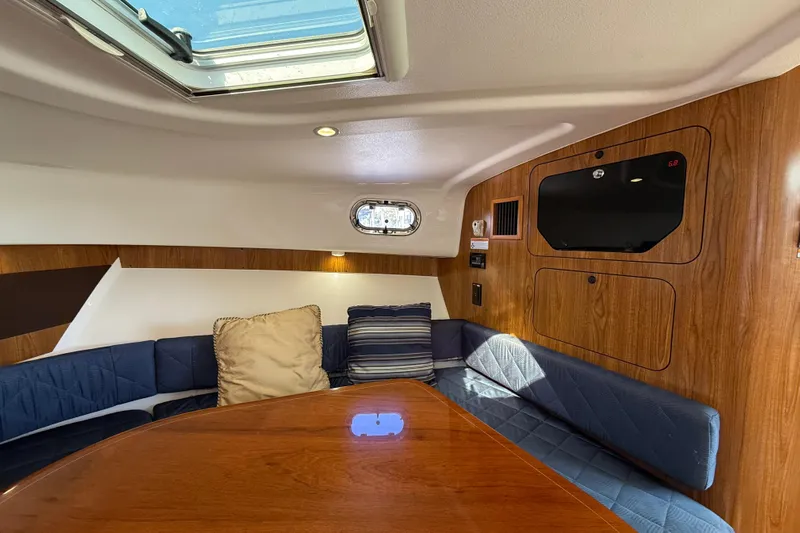  Yacht Photos Pics 2010 Pursuit OS 345 Offshore cabin interior with wood paneling and blue seating.