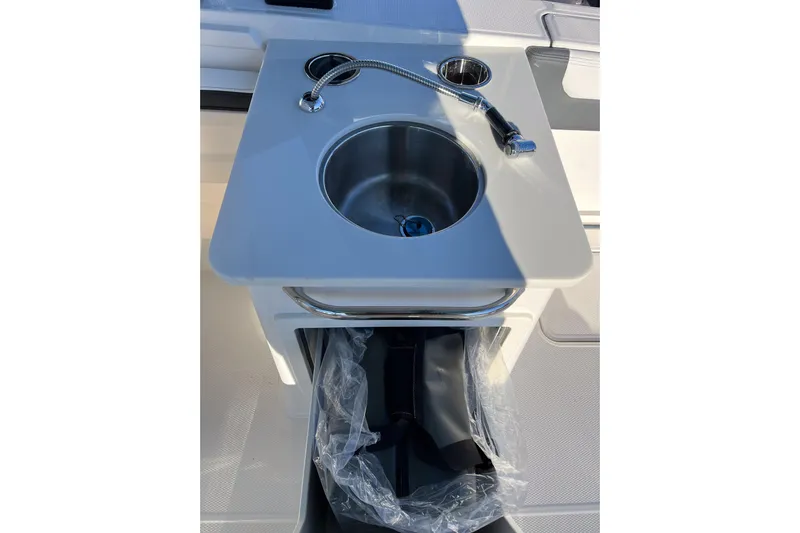  Yacht Photos Pics 2026 Robalo R257 Dual Console boat sink with faucet and storage compartment.