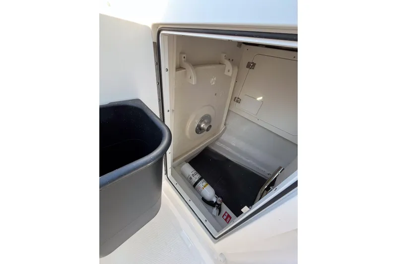  Yacht Photos Pics 2026 Robalo R257 Dual Console storage compartment with fire extinguisher and trash bin.
