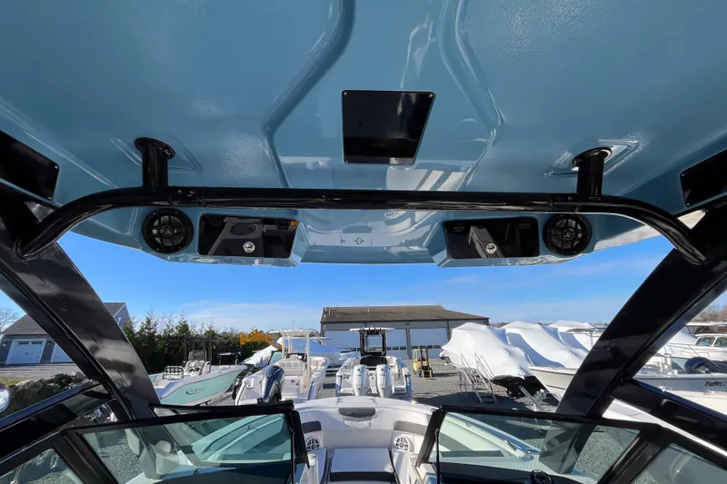  Yacht Photos Pics 2026 Robalo R257 Dual Console boat interior with speakers and blue canopy.