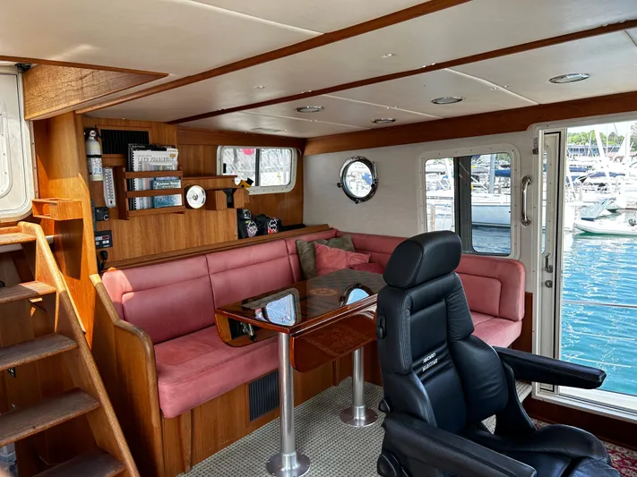 "o My Papa" Yacht Photos Pics Interior of 2003 Nordic Tug 52 with pink seating, wooden accents, and marina view.