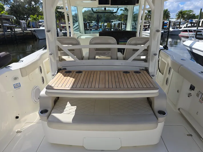  Yacht Photos Pics 2019 Boston Whaler 380 Outrage interior with seating and wooden deck, docked at marina.