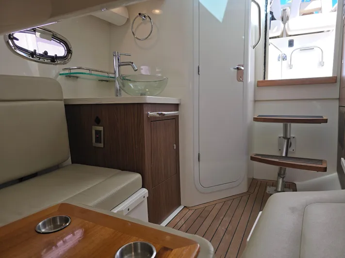  Yacht Photos Pics Interior of 2019 Boston Whaler 380 Outrage, featuring modern seating and compact kitchenette.